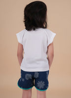 Person wearing a white top and blue patterned shorts on a gray background