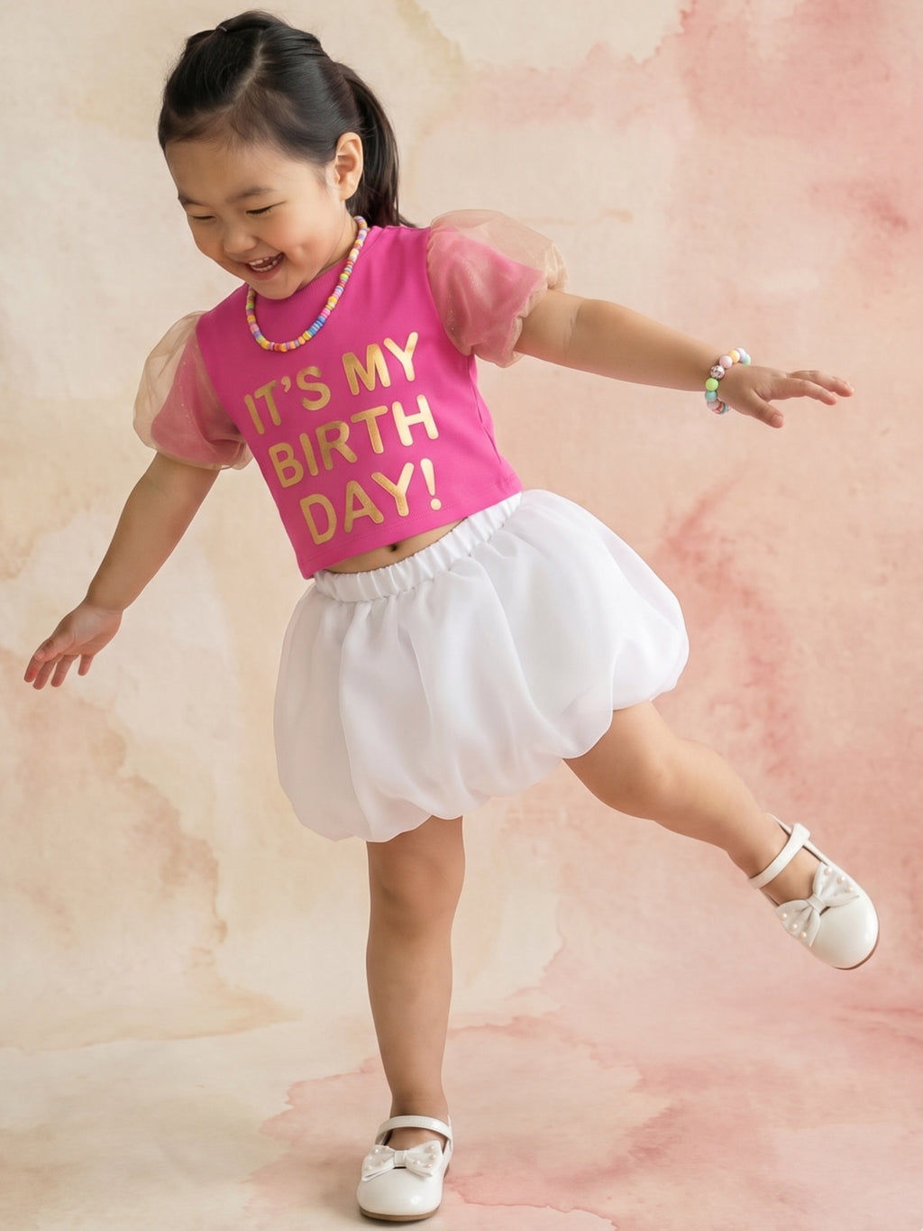 A young girl posing in Birthday Co-ord  from Pink Skies Collection by Little Carrot