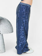 A little girl dazzles in a navy blue sequined co-ord set, featuring a chic crop top and straight pants with a glitter elastic waistband. Styled with shimmering shoes and surrounded by disco-inspired décor, this premium kids' wear ensemble is designed for a glamorous look with maximum comfort. Perfect for ages 3-14! ✨💙