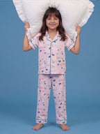 A girl posing in a playful pose with pillow wearing Little Carrot Butterfly printed night suit in peach color