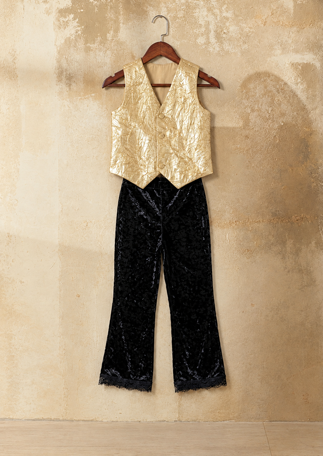 A young girl is posing in Gold vest and black velvet set from pink skies by Little Carrot