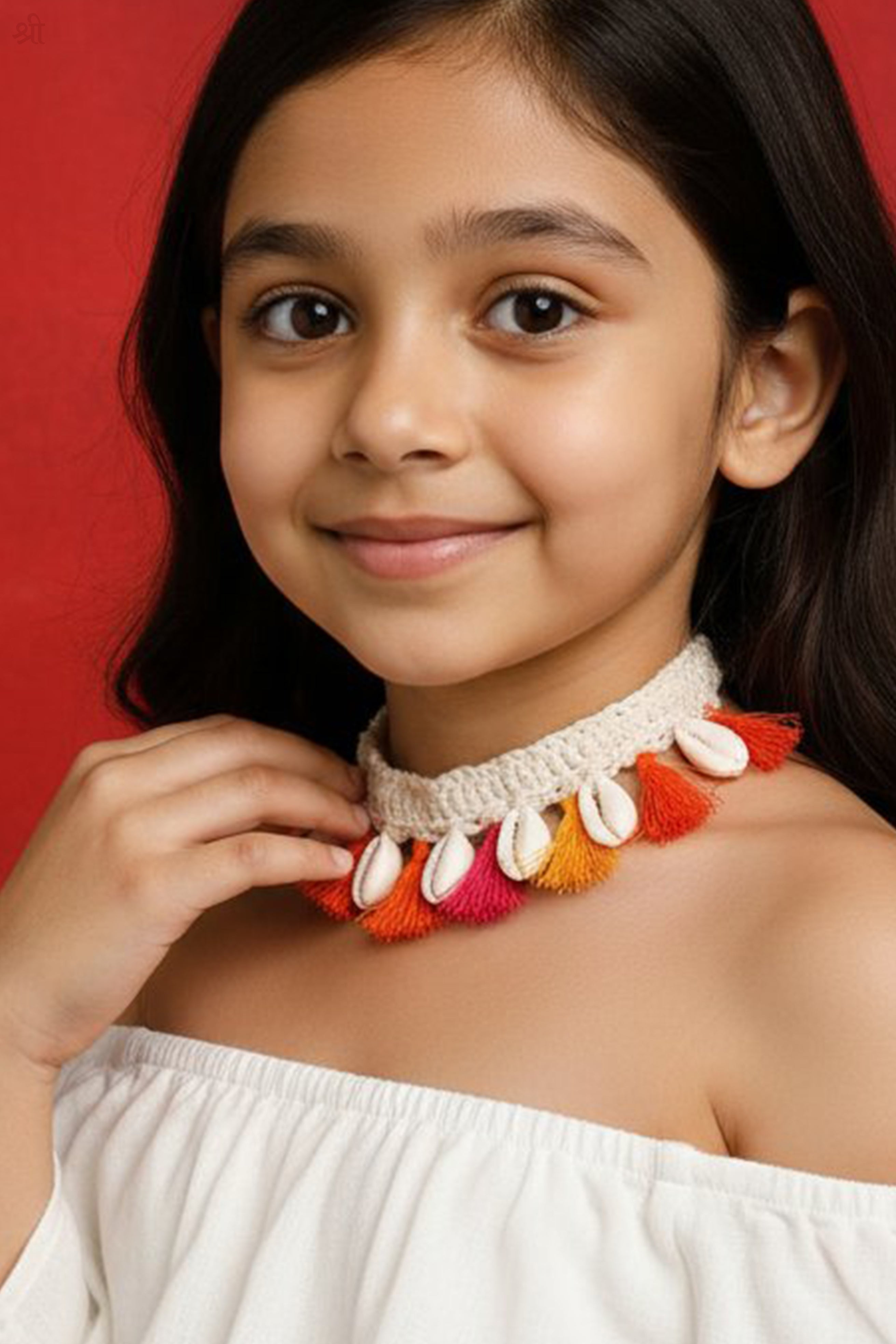 Young girl wearing a Crochet colorful necklace by Little Carrot, against a red background