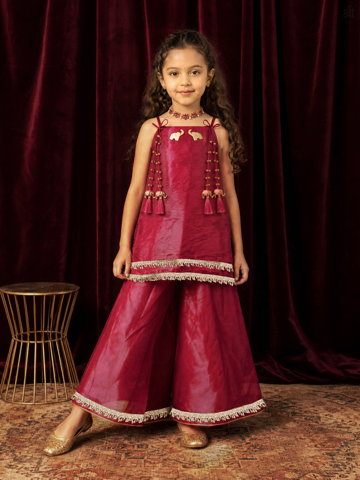 A young girl posing in Little Carrot Kurti Palazzo Set with elephant and ghungroo Detailing