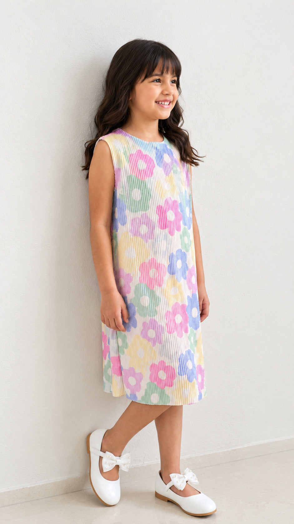 A young girl happily posing in Pastel Floal Dress from Pink Skies Collection by Little Carrot