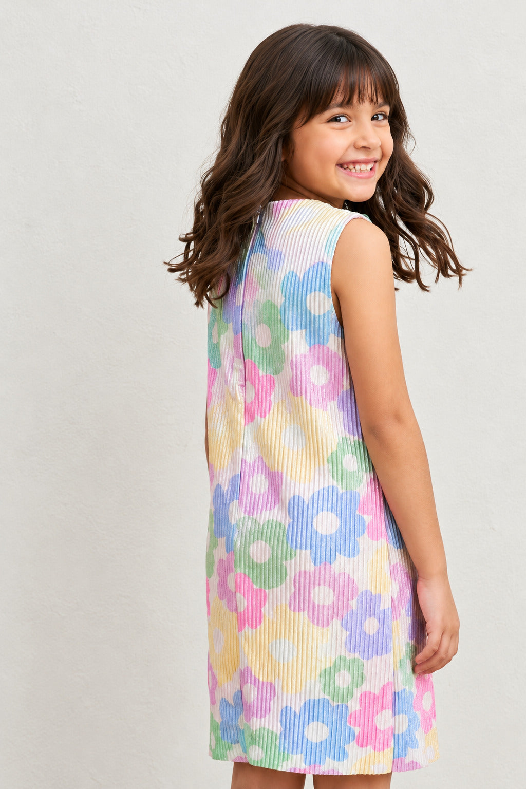 A young girl happily posing in Pastel Floal Dress from Pink Skies Collection by Little Carrot