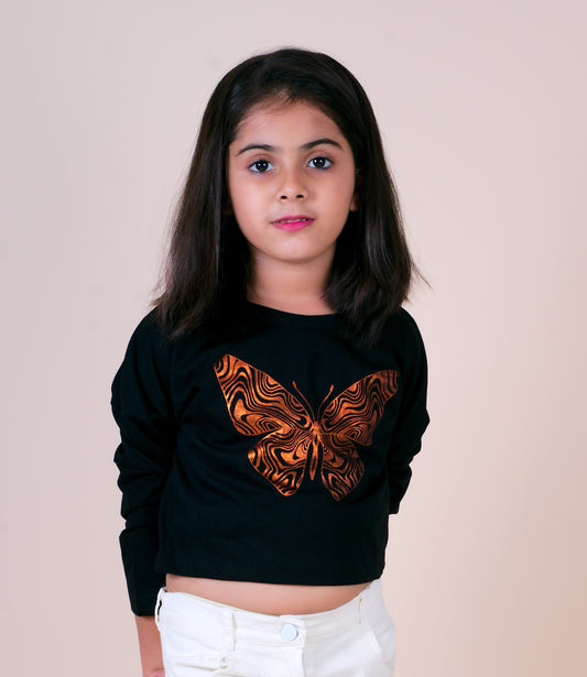 Young girl wearing a black sweater with a butterfly design on a beige background