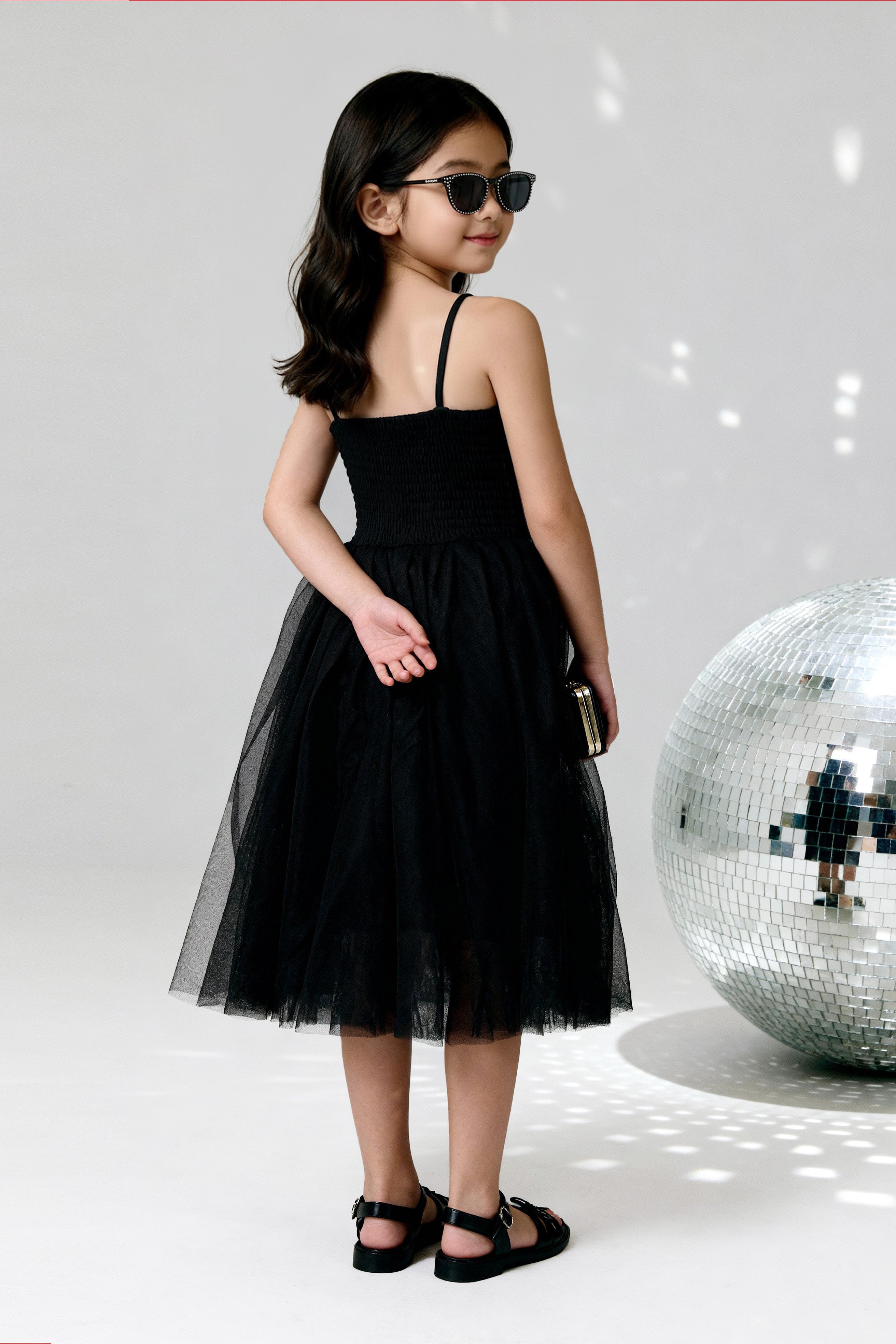 Young girl wearing a Little Carrot floral patterned Sequinned Tutu Dress on a white background