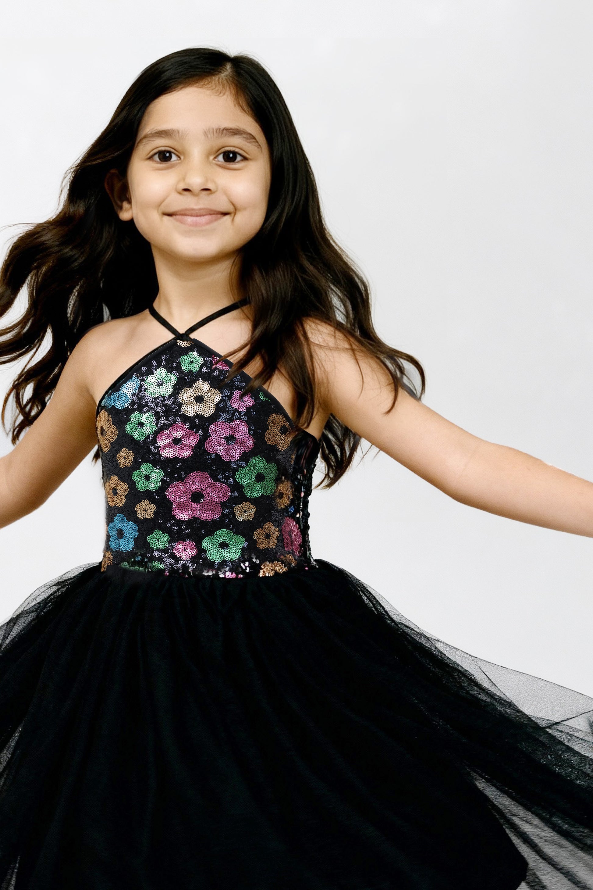 Young girl wearing a Little Carrot floral patterned Sequinned Tutu Dress on a white background