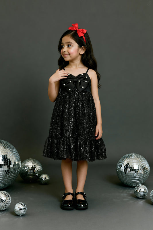 A girlposing in Little Carrot premium satin tulle dress. It has Sequin bow highlight with Hand embellished pear highlights