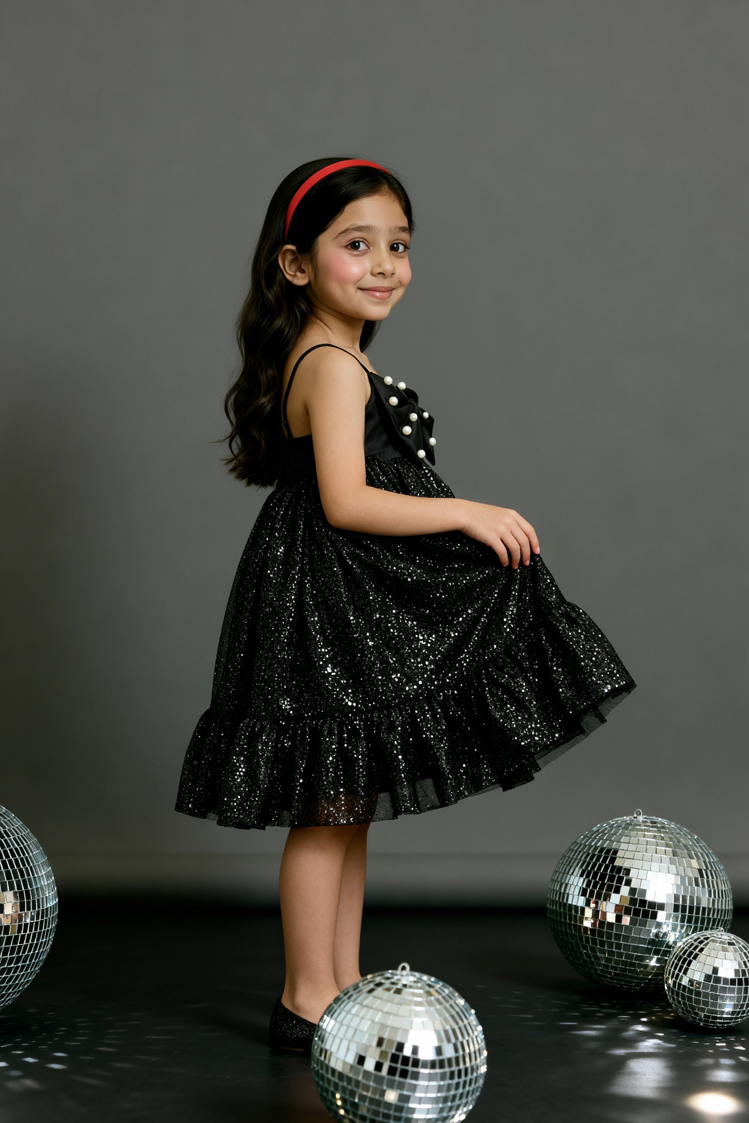 A girlposing in Little Carrot premium satin tulle dress. It has Sequin bow highlight with Hand embellished pear highlights