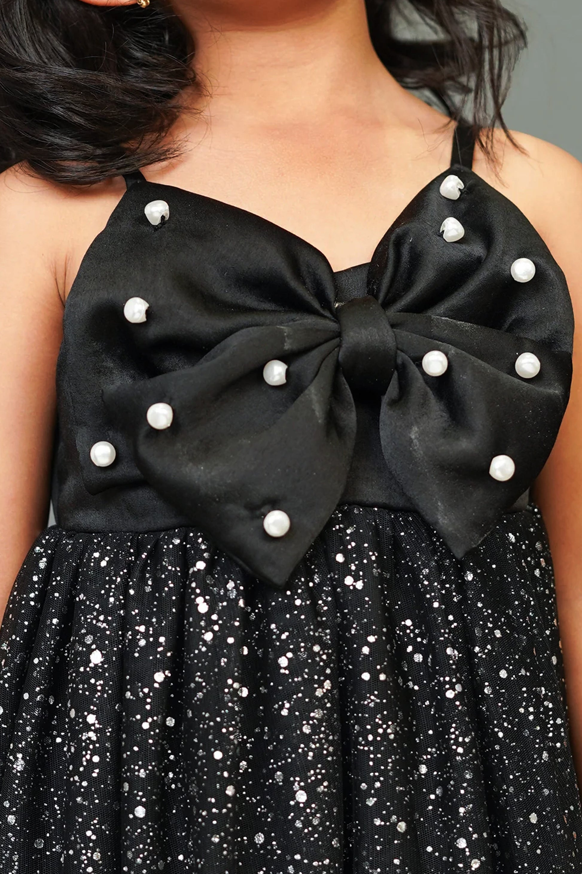 A girlposing in Little Carrot premium satin tulle dress. It has Sequin bow highlight with Hand embellished pear highlights