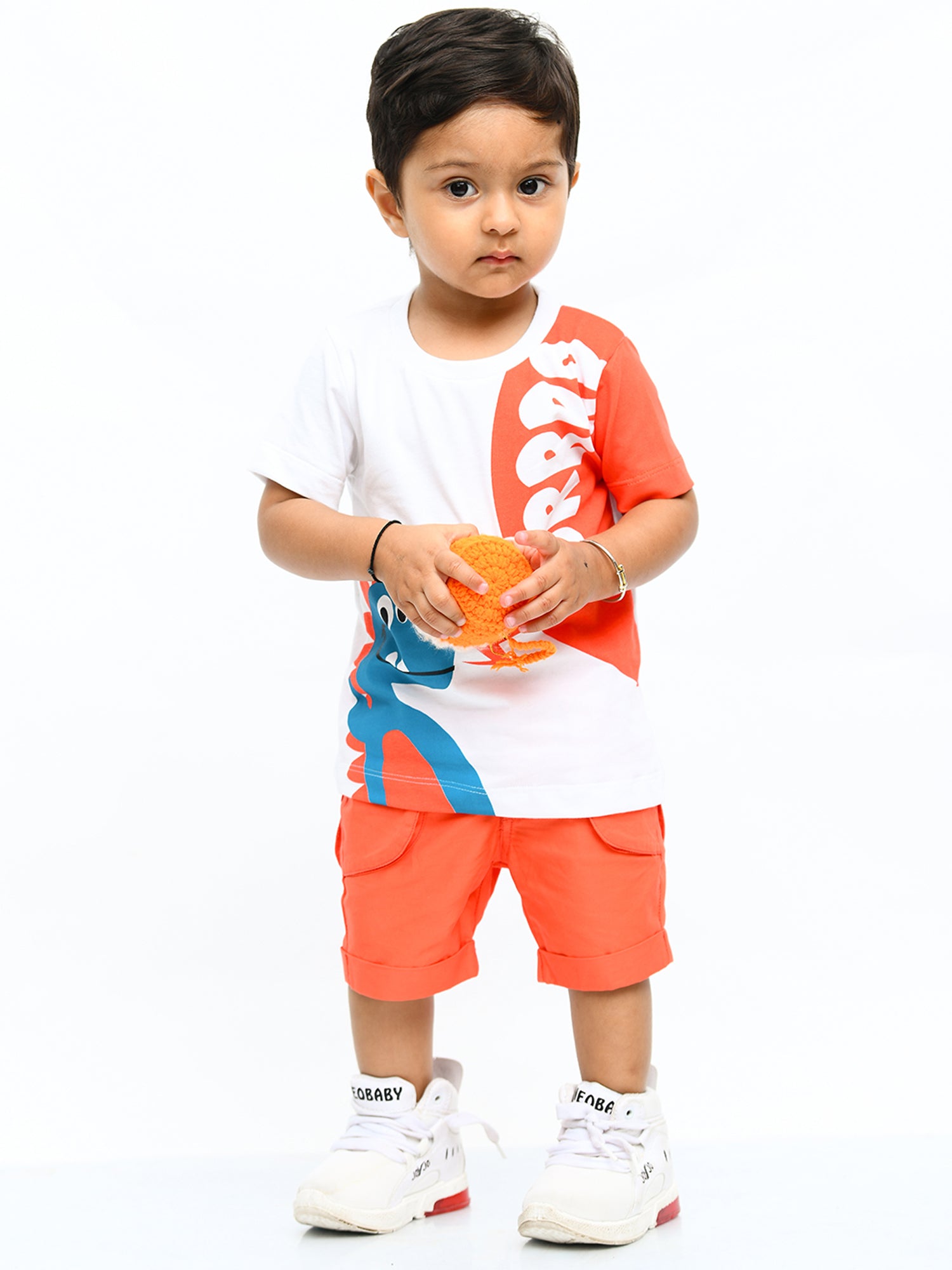 Infant boy wearing a cheerful orange sunshine co-ord set with playful cartoon print – ideal cotton outfit for toddlers in summer