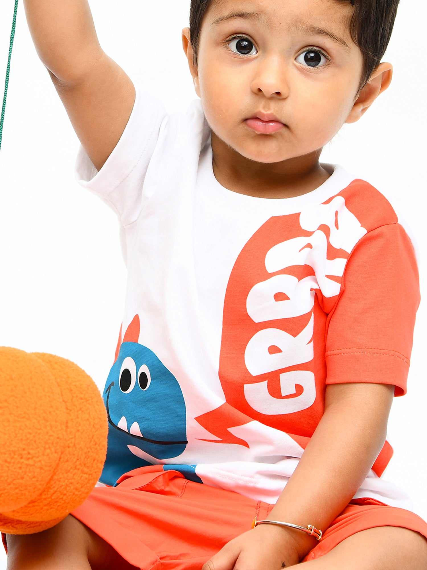 Infant boy wearing a cheerful orange sunshine co-ord set with playful cartoon print – ideal cotton outfit for toddlers in summer