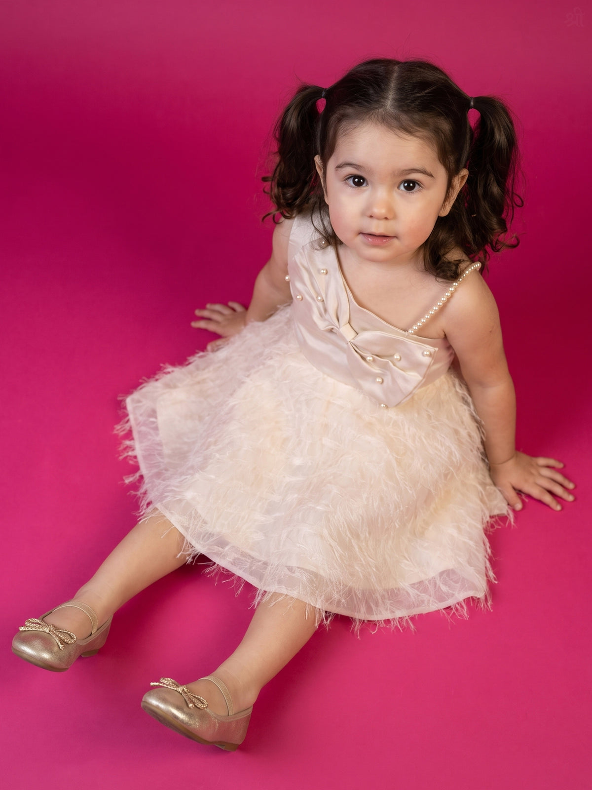 A young girl posing in Satin bow and Fur Flare Dress from Pink Skies Collection by Little Carrot