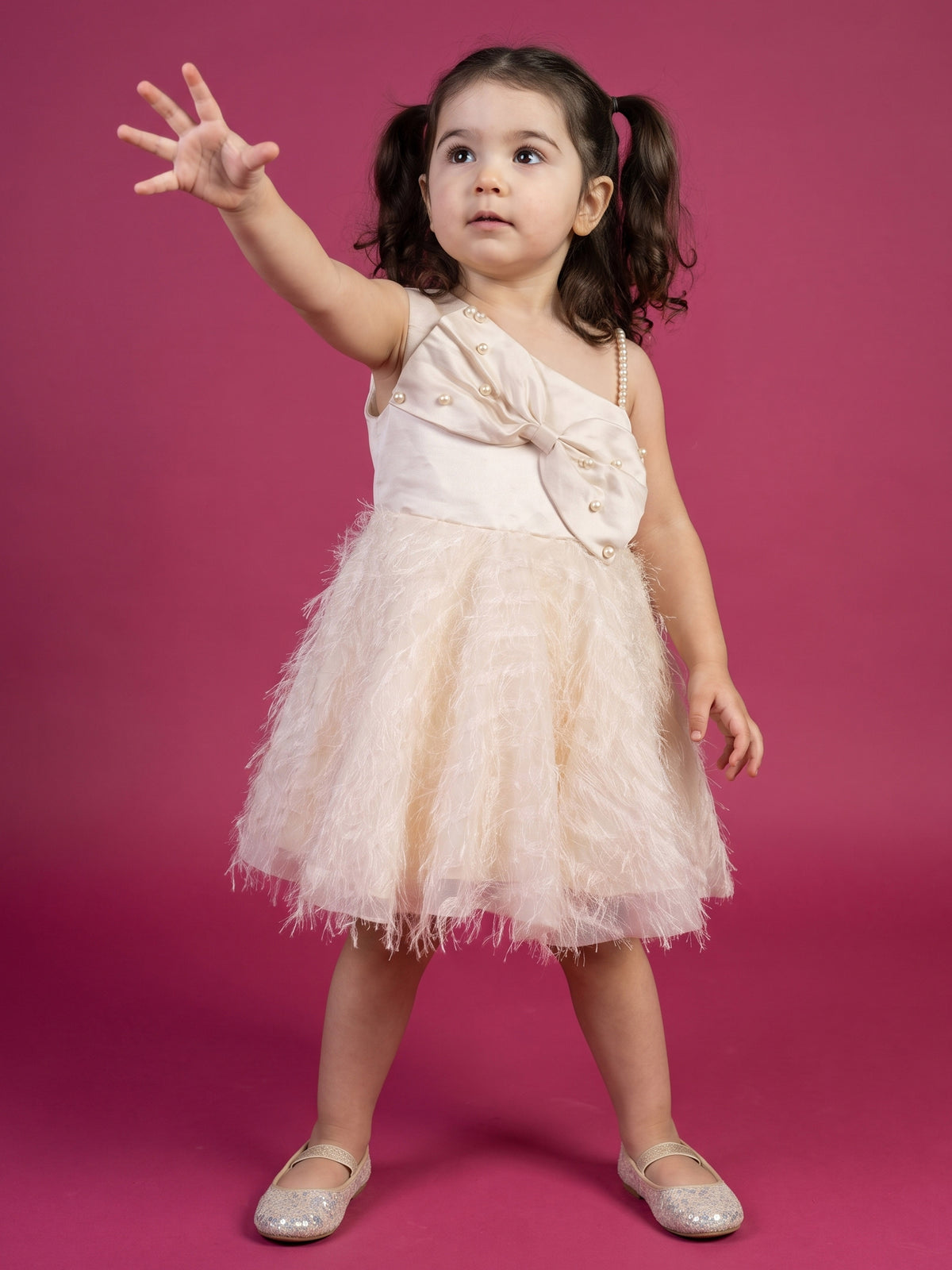 A young girl posing in Satin bow and Fur Flare Dress from Pink Skies Collection by Little Carrot