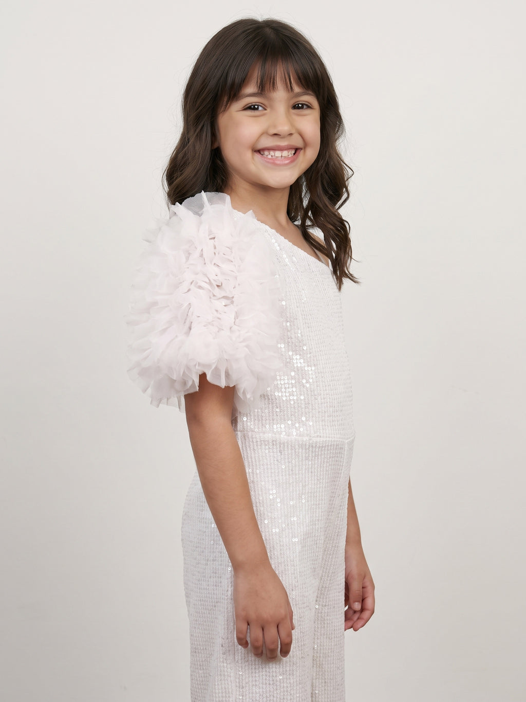 A young girl showing side angle of Little Carrot White Sequins Jumpsuit