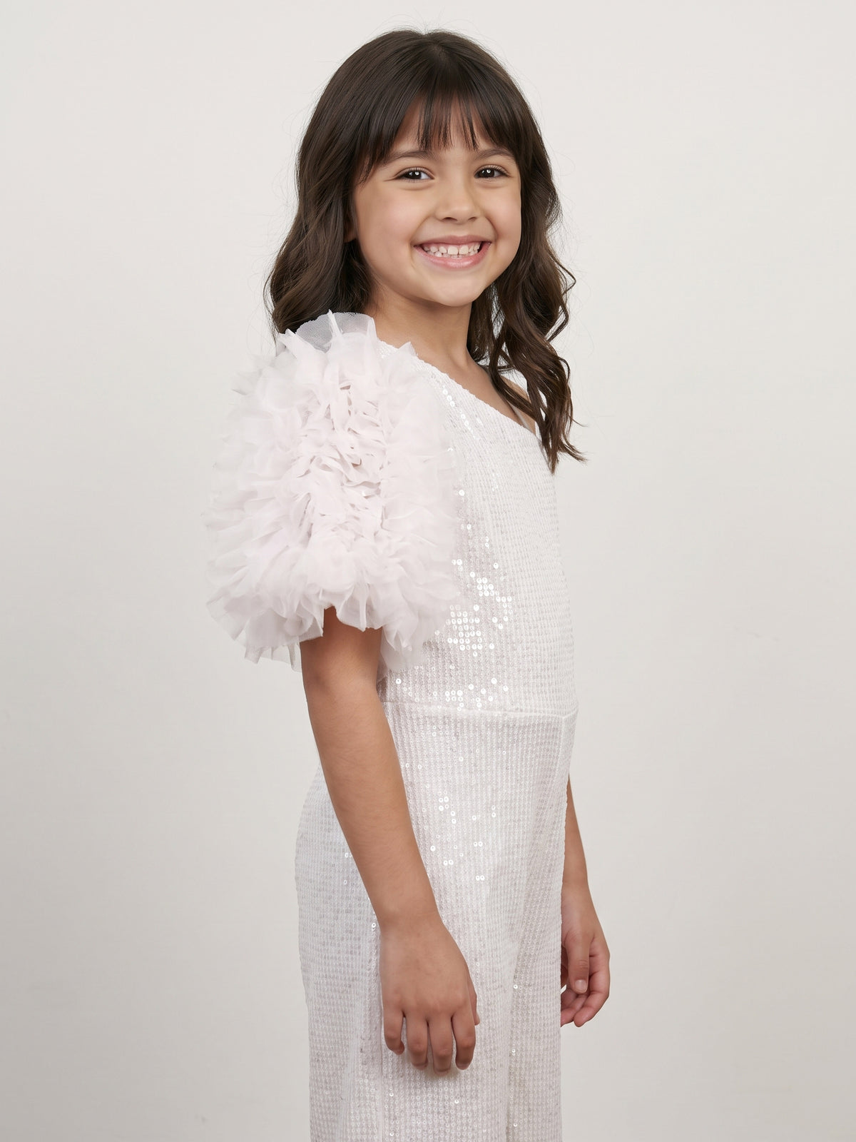 A young girl showing side angle of Little Carrot White Sequins Jumpsuit