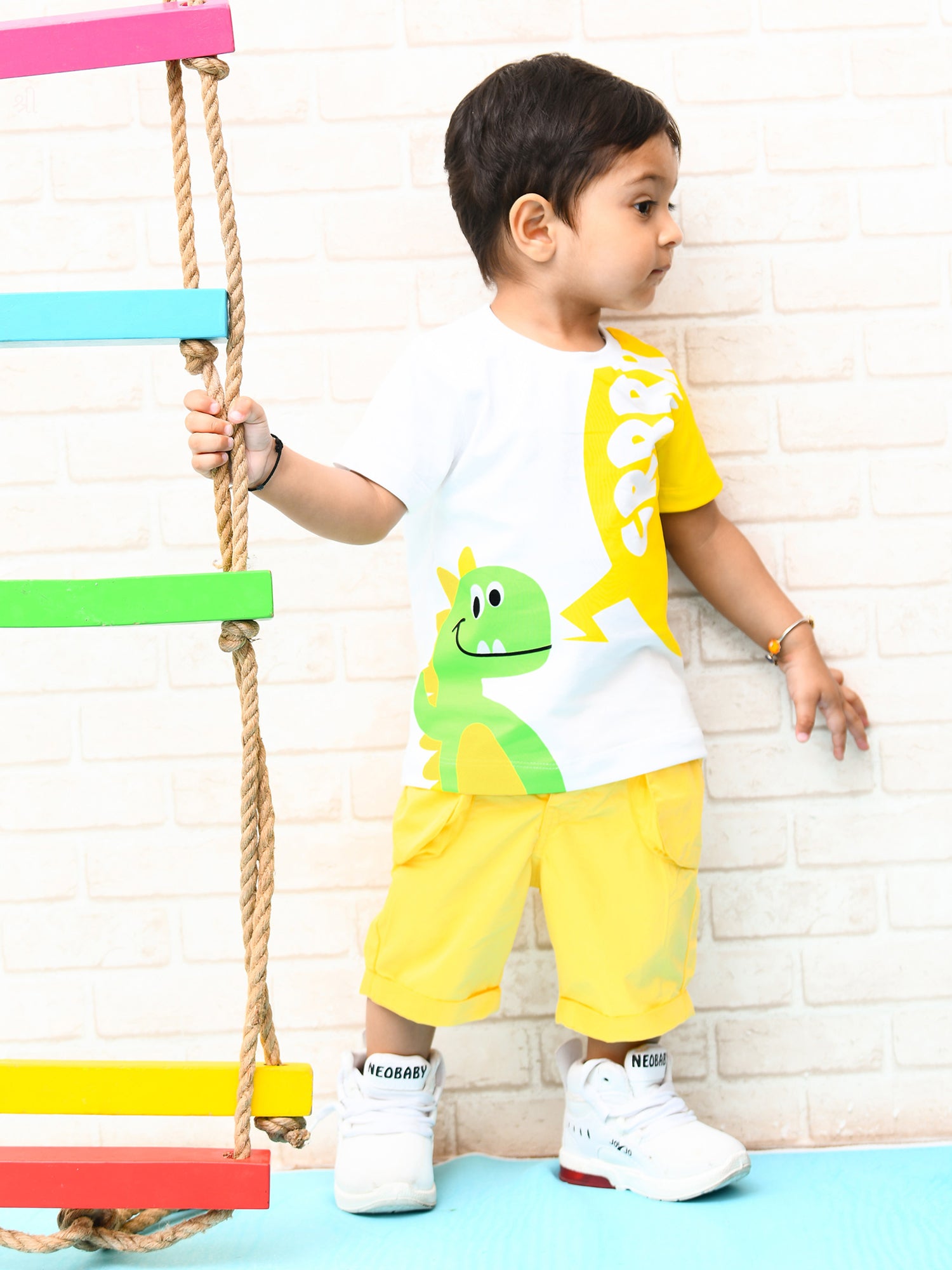 Infant boy wearing a bright yellow sunshine-themed co-ord set with fun cartoon print – perfect cotton outfit for playful summer days