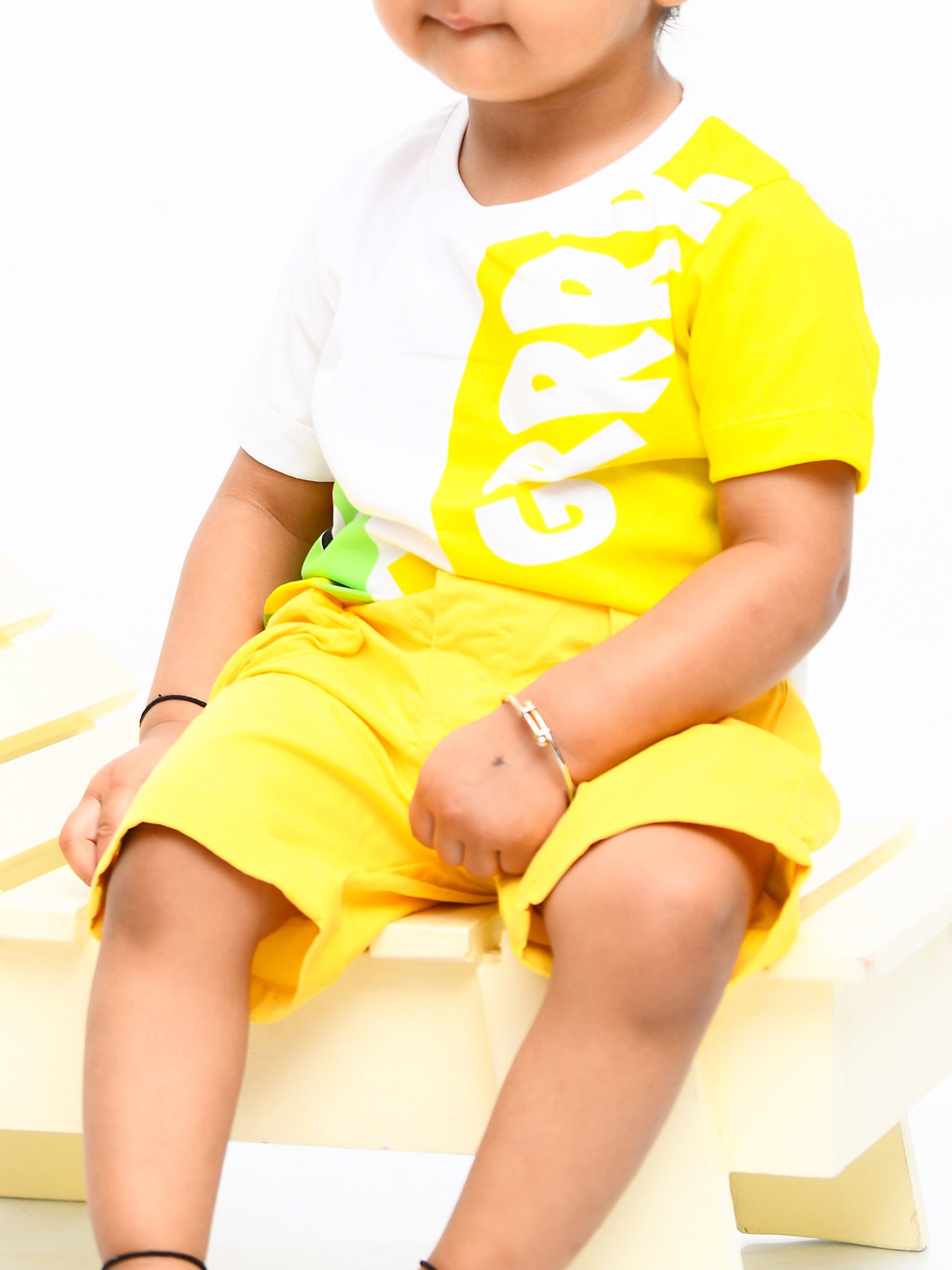 Infant boy wearing a bright yellow sunshine-themed co-ord set with fun cartoon print – perfect cotton outfit for playful summer days