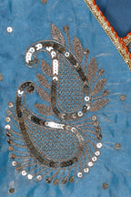 Close-up of intricate paisley pattern with sequins on a blue fabric background by little carrot