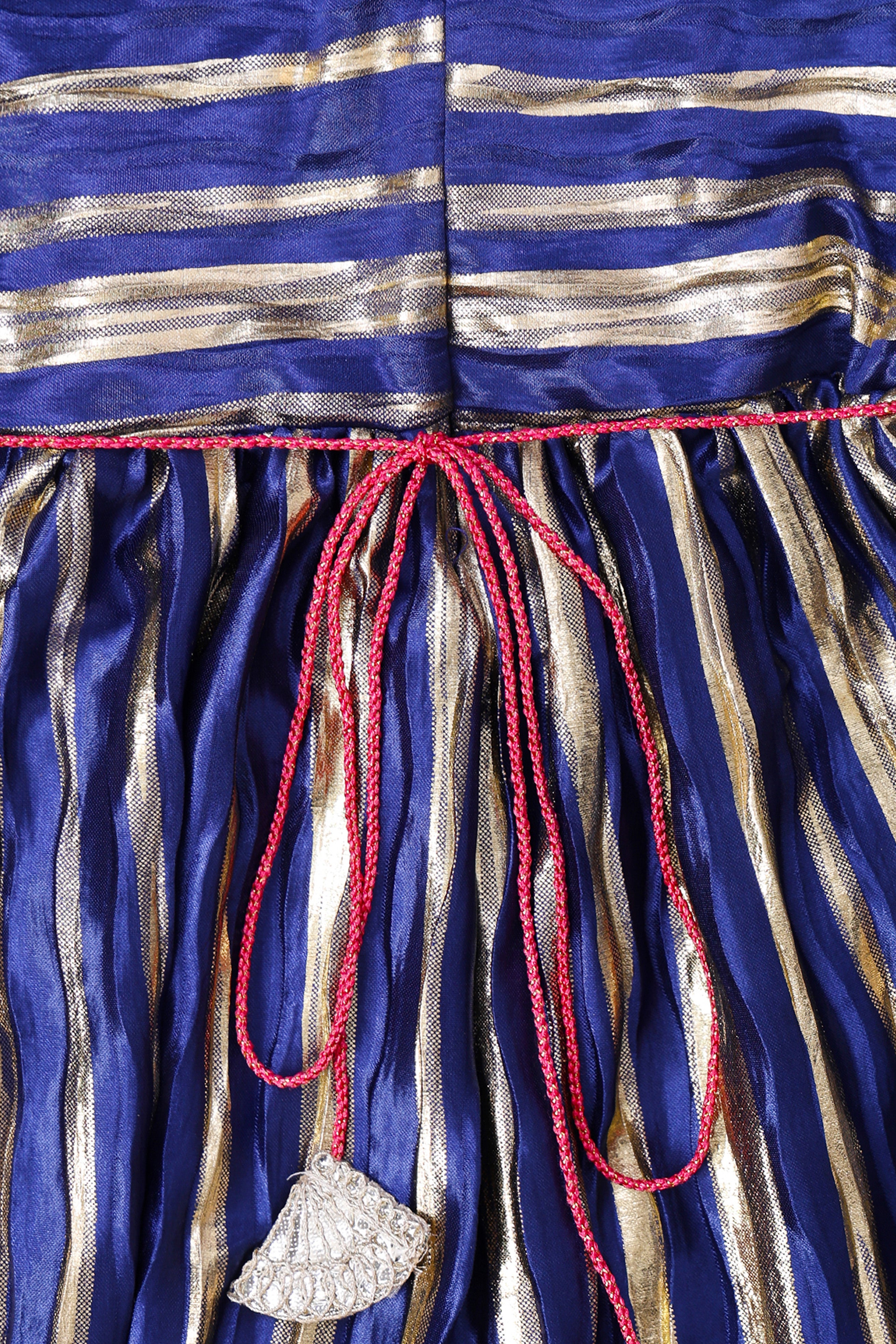 Close-up of a little carrot blue and gold striped Kurti with a red drawstring and decorative element.