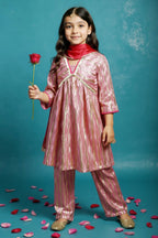A cute indian standing wearing little carrot Light pink gold Anarkali Kurta Set with Dupatta embellished with laces, with  a red rose in her hand