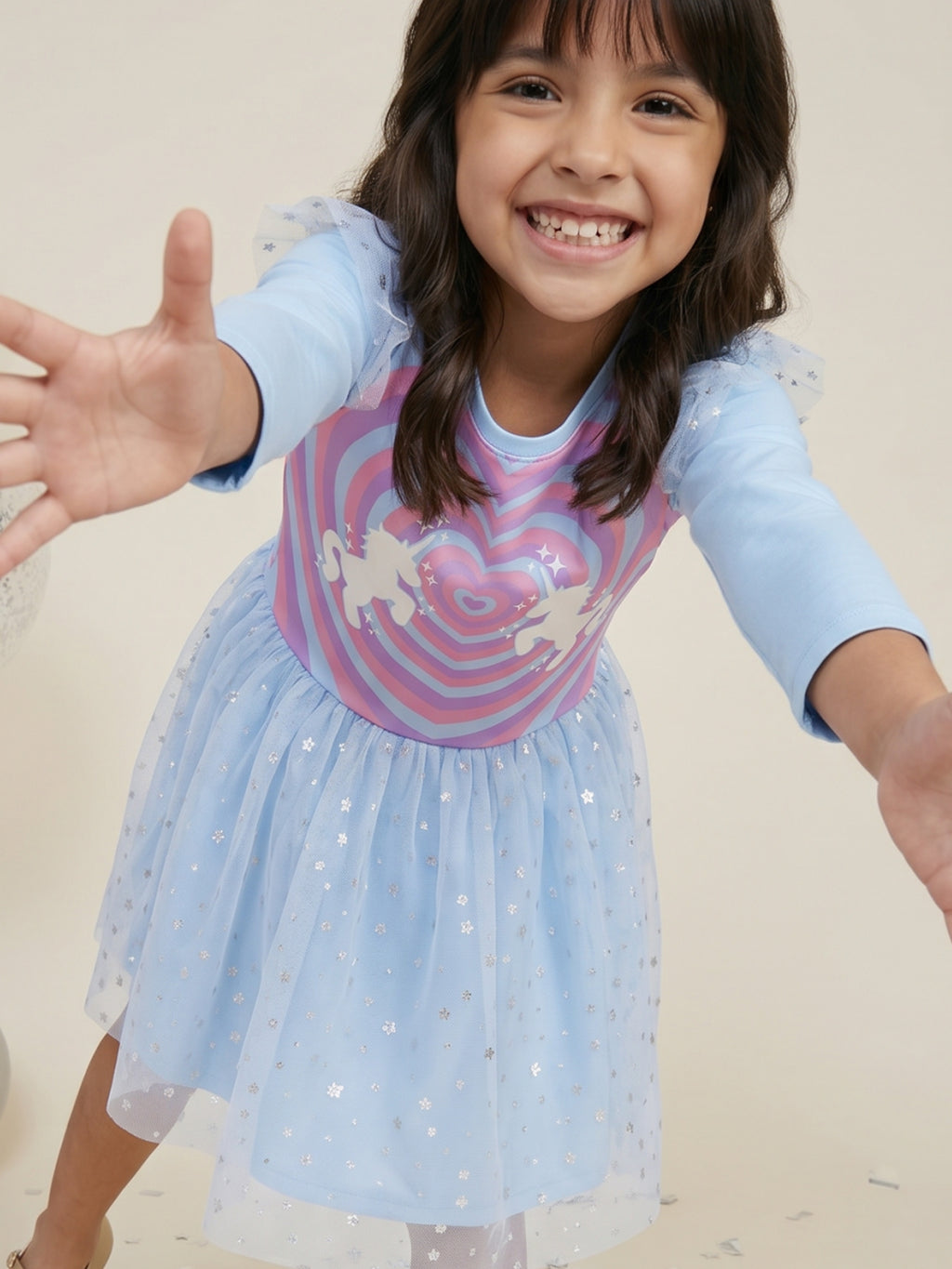 A young happy girl is posing in Little Carrot Blue Unicorn Dress