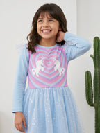 A young happy girl is posing in Little Carrot Blue Unicorn Dress