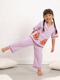 Girl wearing little carrot pink pajamas night suit with teddy design on a white background
